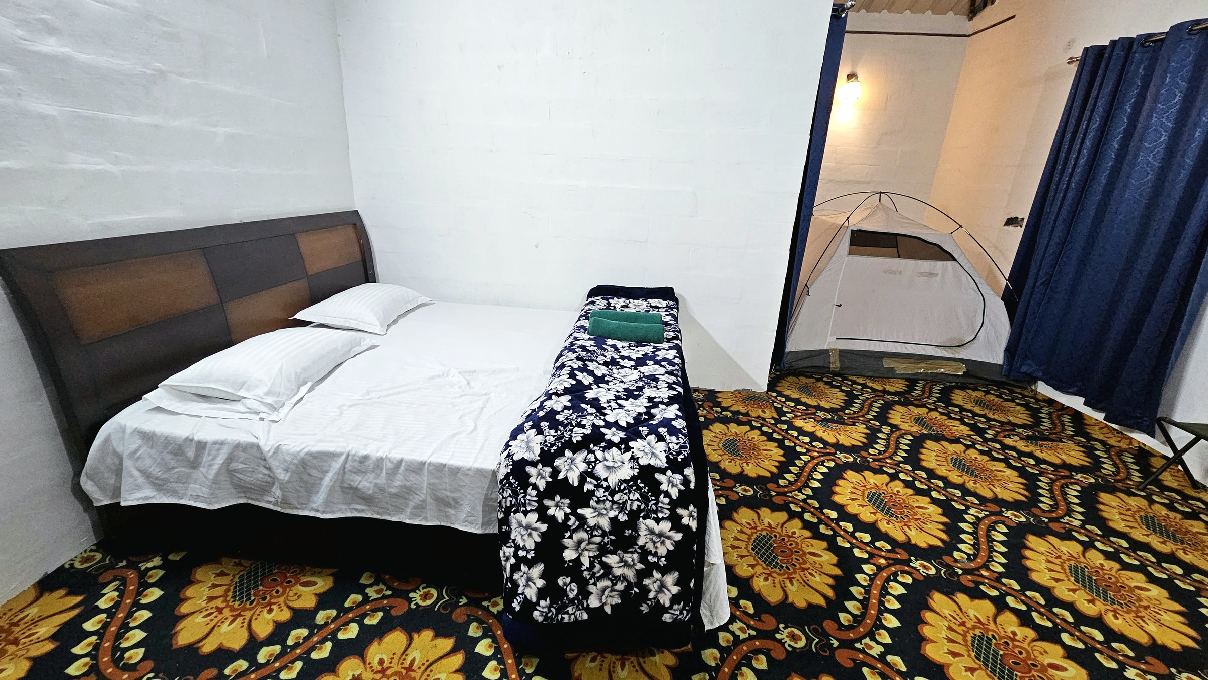 Cottage bedroom with double bed and colourful carpet at The Glide Inn Shimla