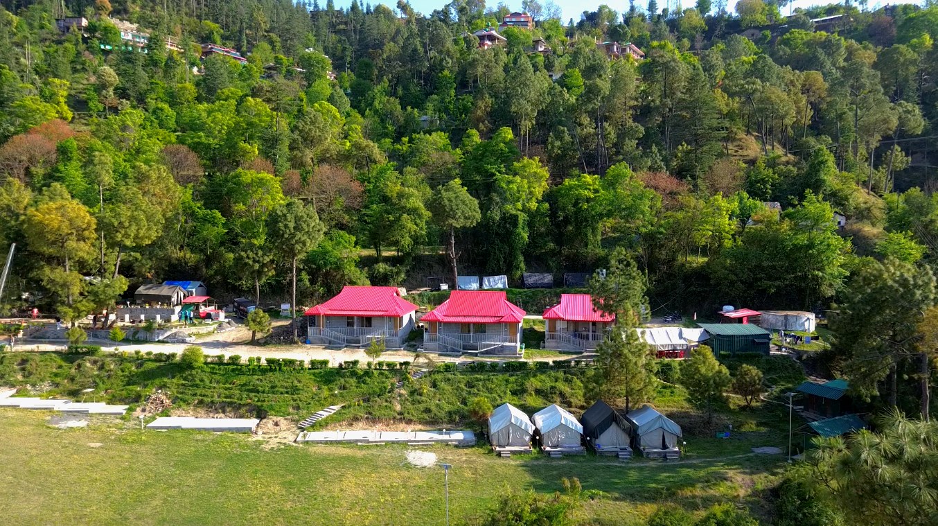 Aerial drone view of The Glide Inn resort showing cottages tents and forest